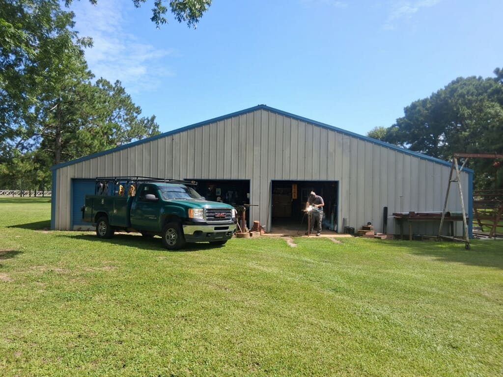 The Albert's Specialty Welding shop in Irvington, Alabama, with the green service-bed welding truck parked outside and a welder working in the open bay.