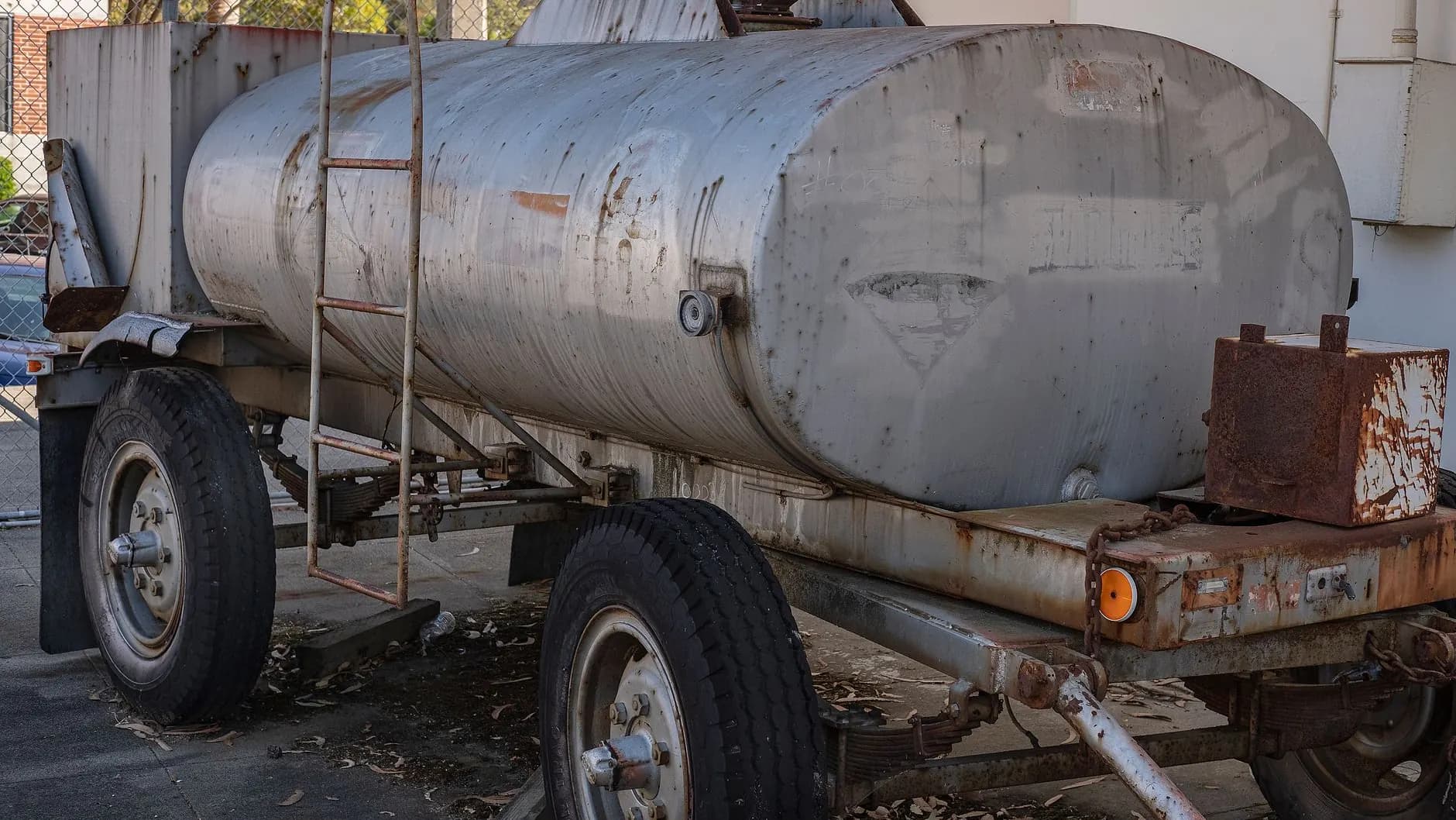 A utility trailer frame being welded and reinforced during repair